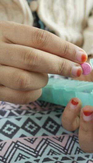 person holding white and green plastic container