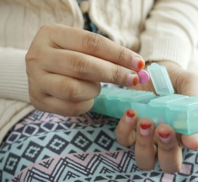person holding white and green plastic container