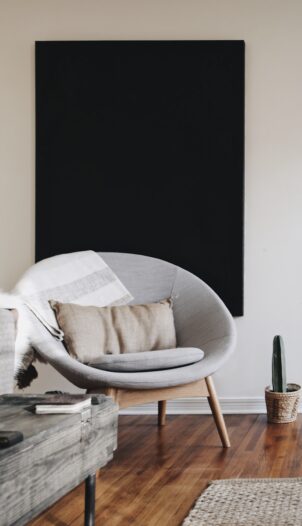 round grey moon chair with brown pillow on top