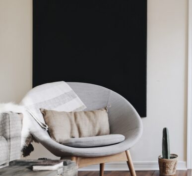 round grey moon chair with brown pillow on top
