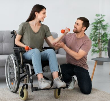 A man in a wheel chair being pushed by a woman
